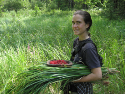 A wilderness guide program seeker carries foraged food.